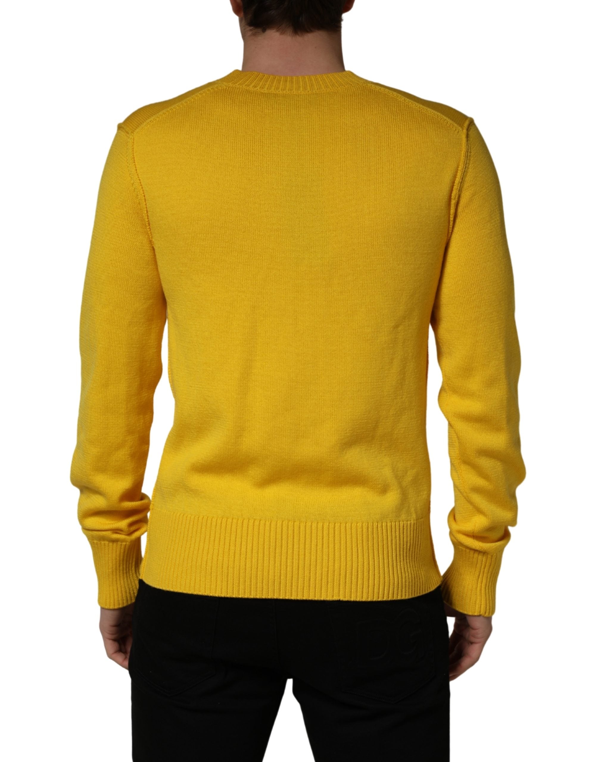 Pull en laine Dolce & Gabbana à col en V, jaune, tricoté, avec une texture douce et confortable visible sur l'image.