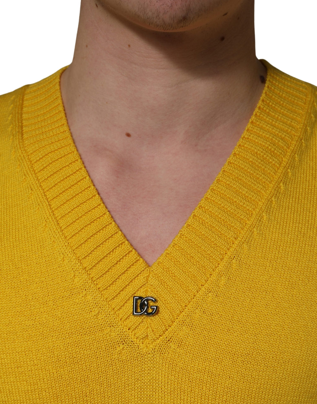 Pull en laine Dolce & Gabbana à col en V de couleur jaune, tricoté, porté sur un mannequin.