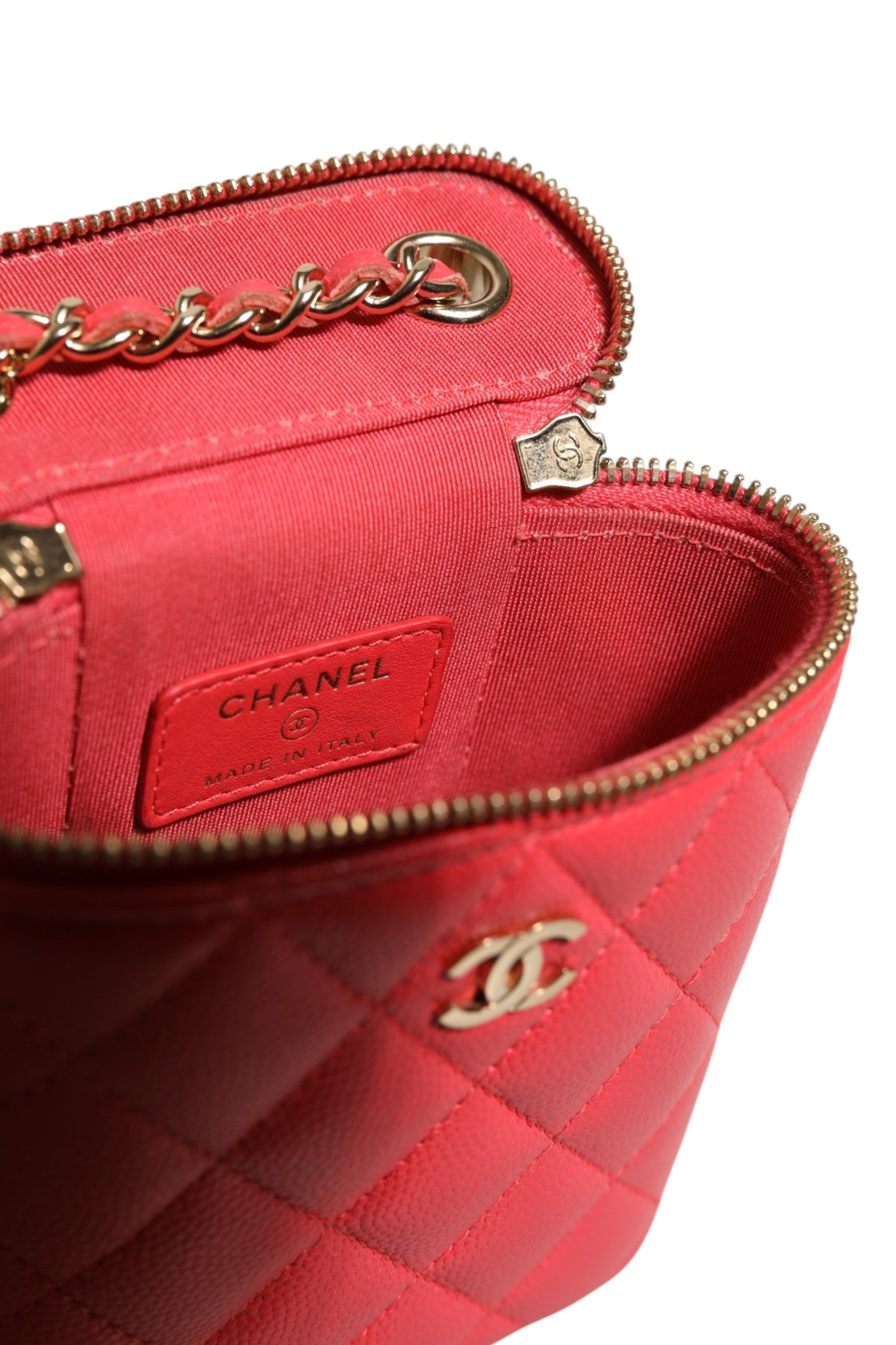 Petite pochette de beauté Chanel rouge en caviar matelassé avec chaîne verticale, design élégant et compact.