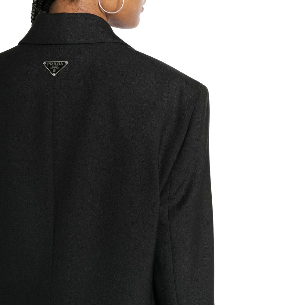 Blazer noir en laine vierge de Prada, veste élégante avec coupe classique et détails sophistiqués, portée sur un mannequin.