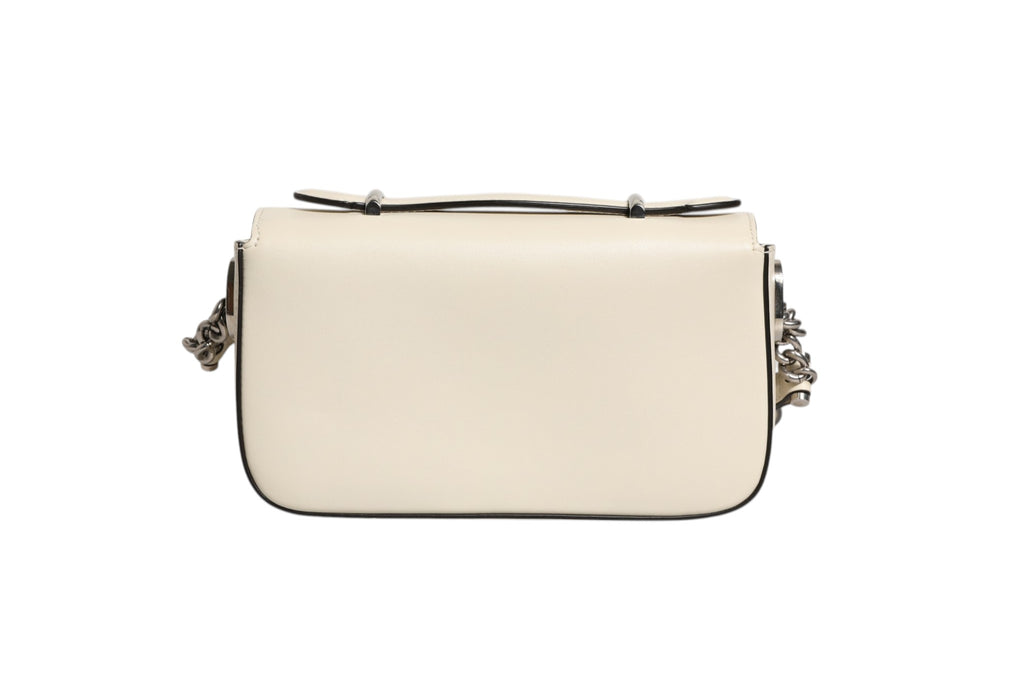 Sac à bandoulière Gucci Petite GG Flap avec fermeture à rabat en cuir et motif monogramme GG, porté sur l'épaule.