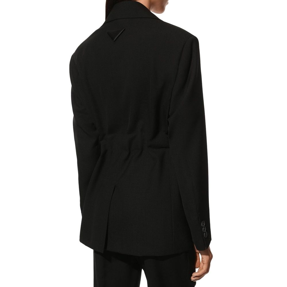 Blazer en laine noire Prada pour homme, coupe classique avec boutons et revers élégants, porté sur un mannequin.