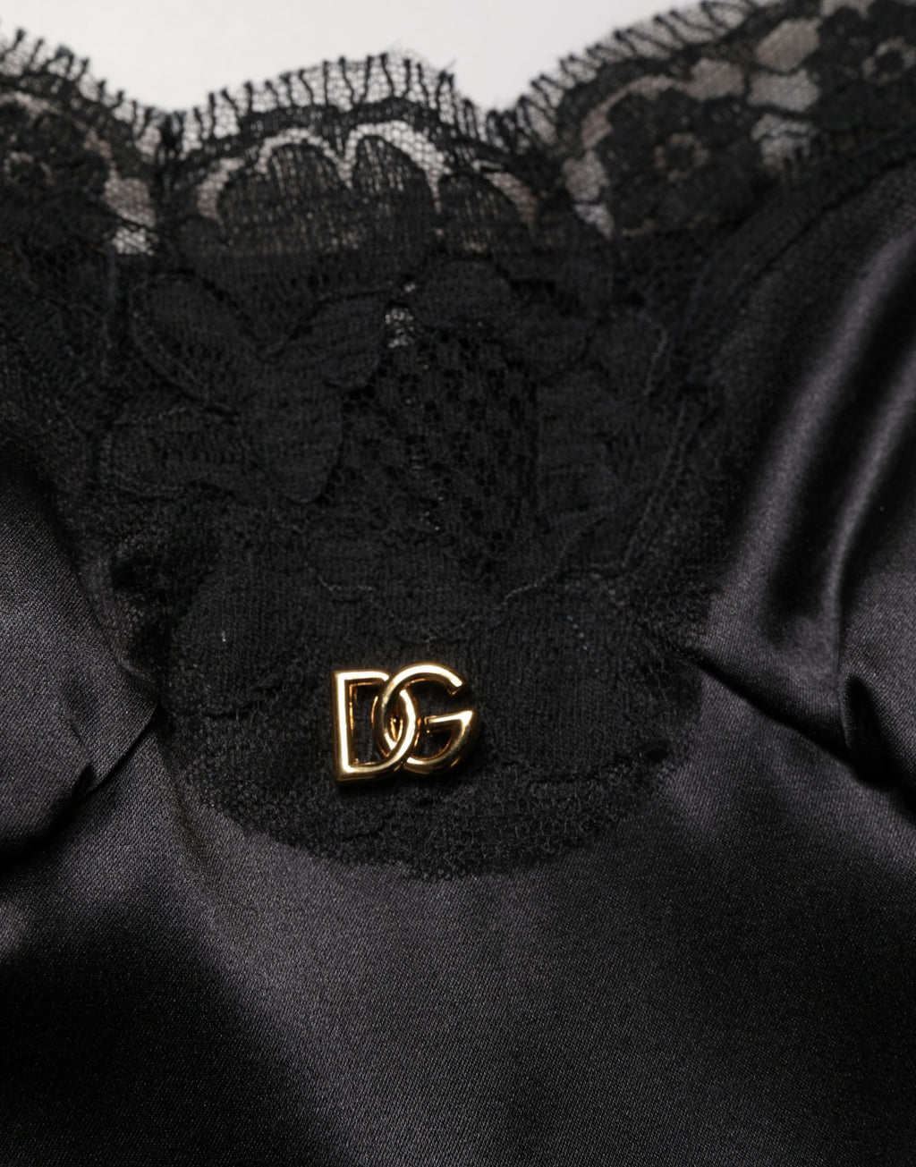 Robe courte en soie satin noir avec dentelle sans manches de Dolce & Gabbana, élégante et sophistiquée.