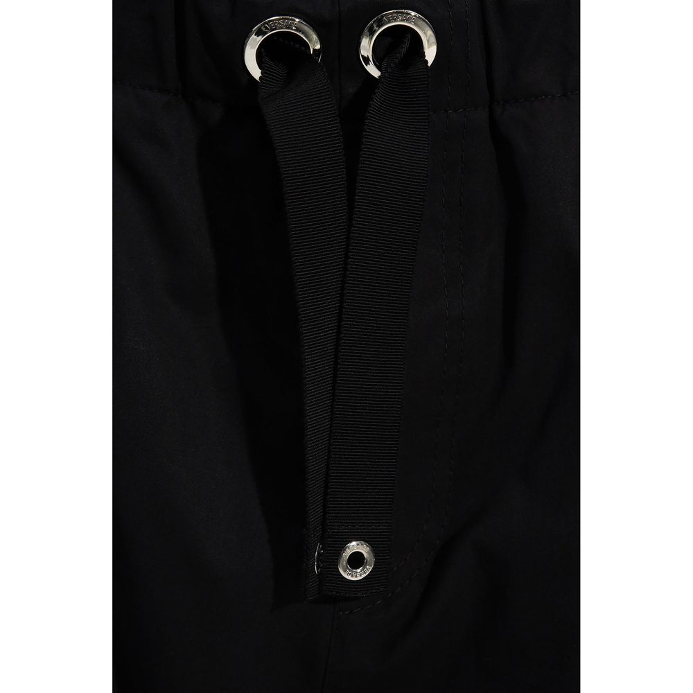 Pantalon décontracté noir en coton de marque Versace, coupe élégante et design simple visible sur l'image.
