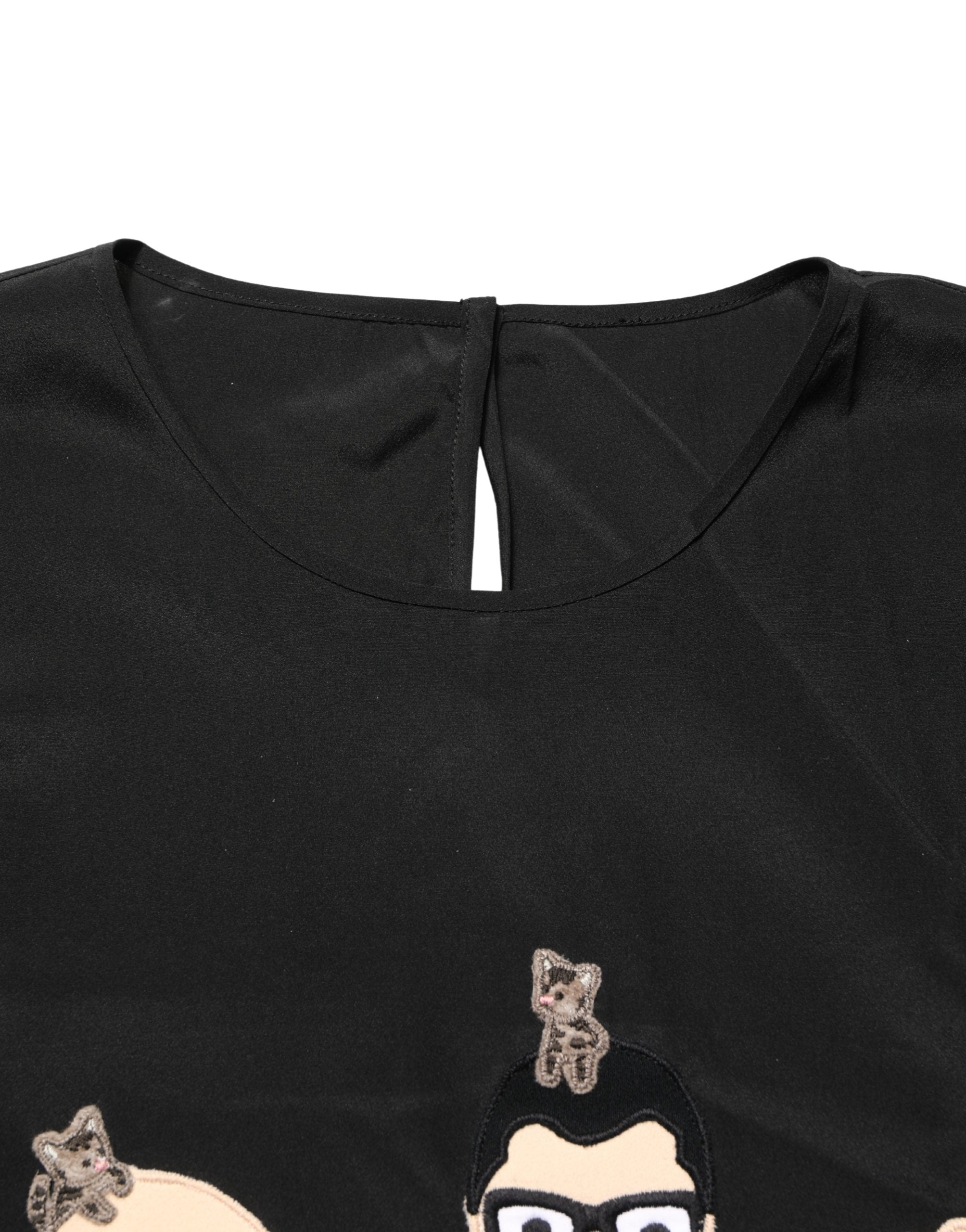 Blouse en soie noire Dolce & Gabbana #dgfamily, top élégant avec design sophistiqué, visible sur fond neutre.