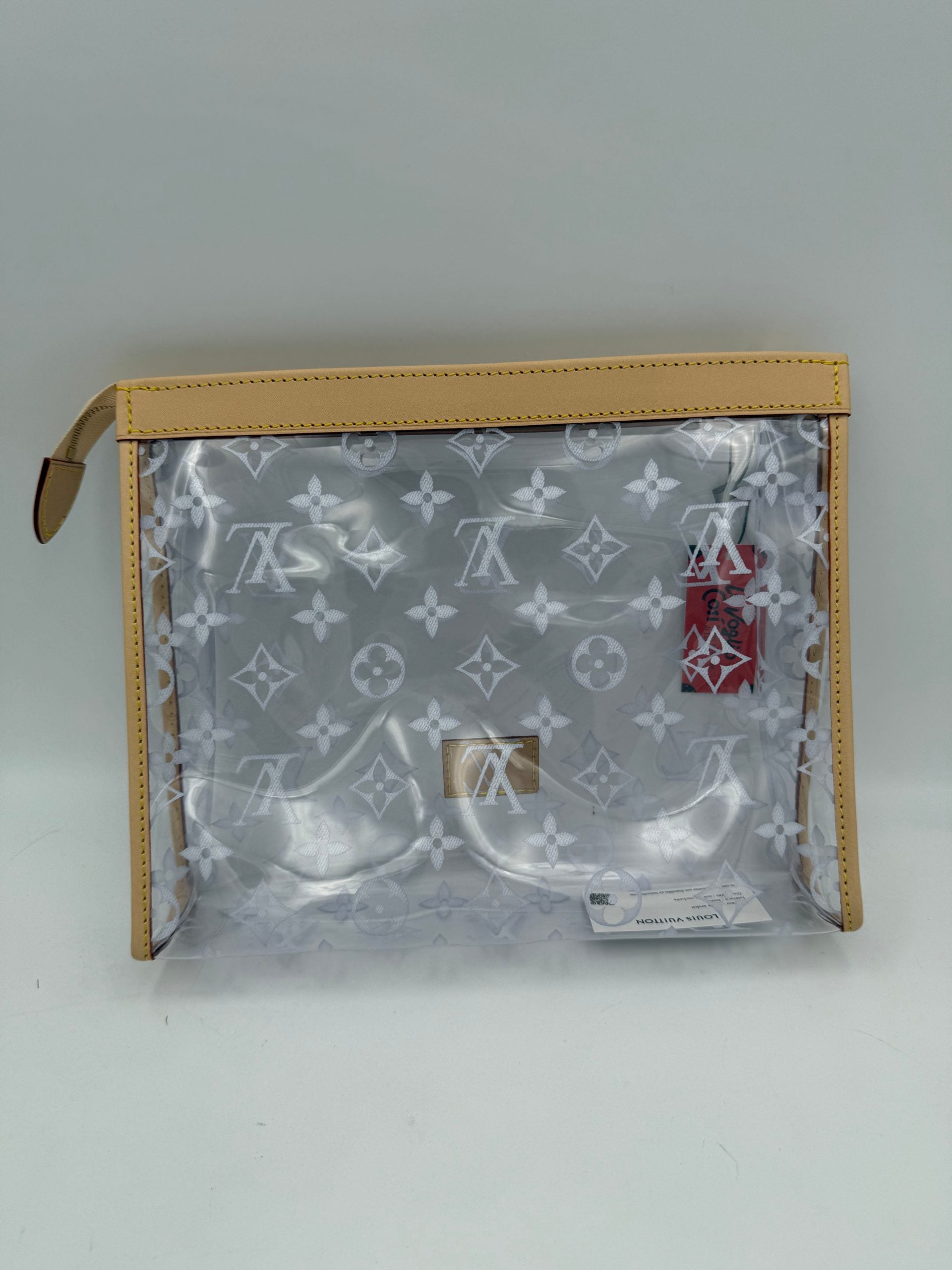 Pochette transparente Louis Vuitton Monogram, sac à main en toile avec logo emblématique, visible en détail.