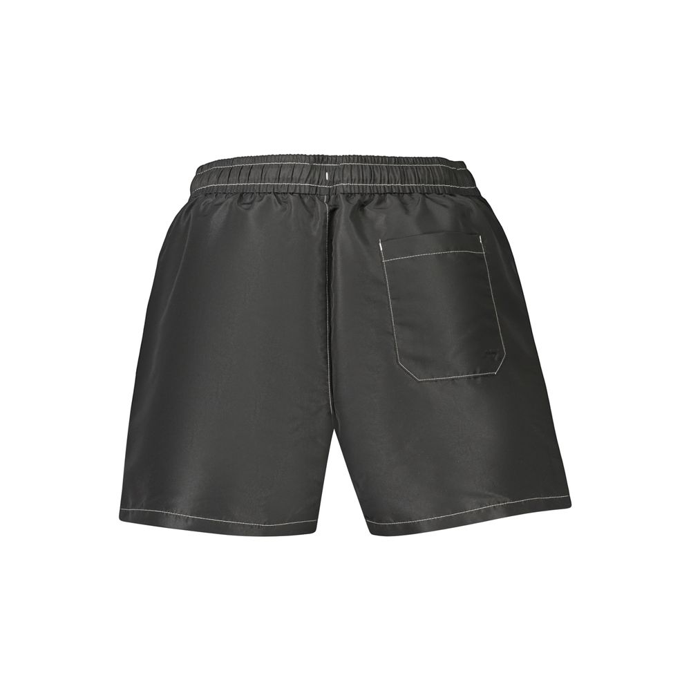 Maillot de bain homme Tommy Hilfiger en polyester noir, style sportif avec logo distinctif, adapté à la plage ou à la piscine.