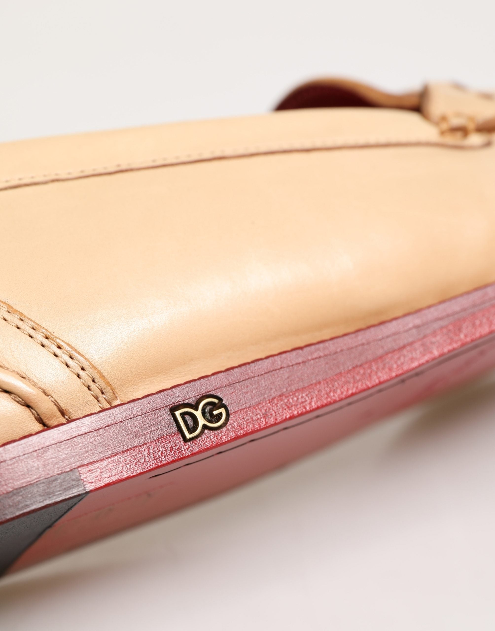 Chaussures mocassins pour homme Dolce & Gabbana en cuir beige avec pampilles, élégantes et confortables.