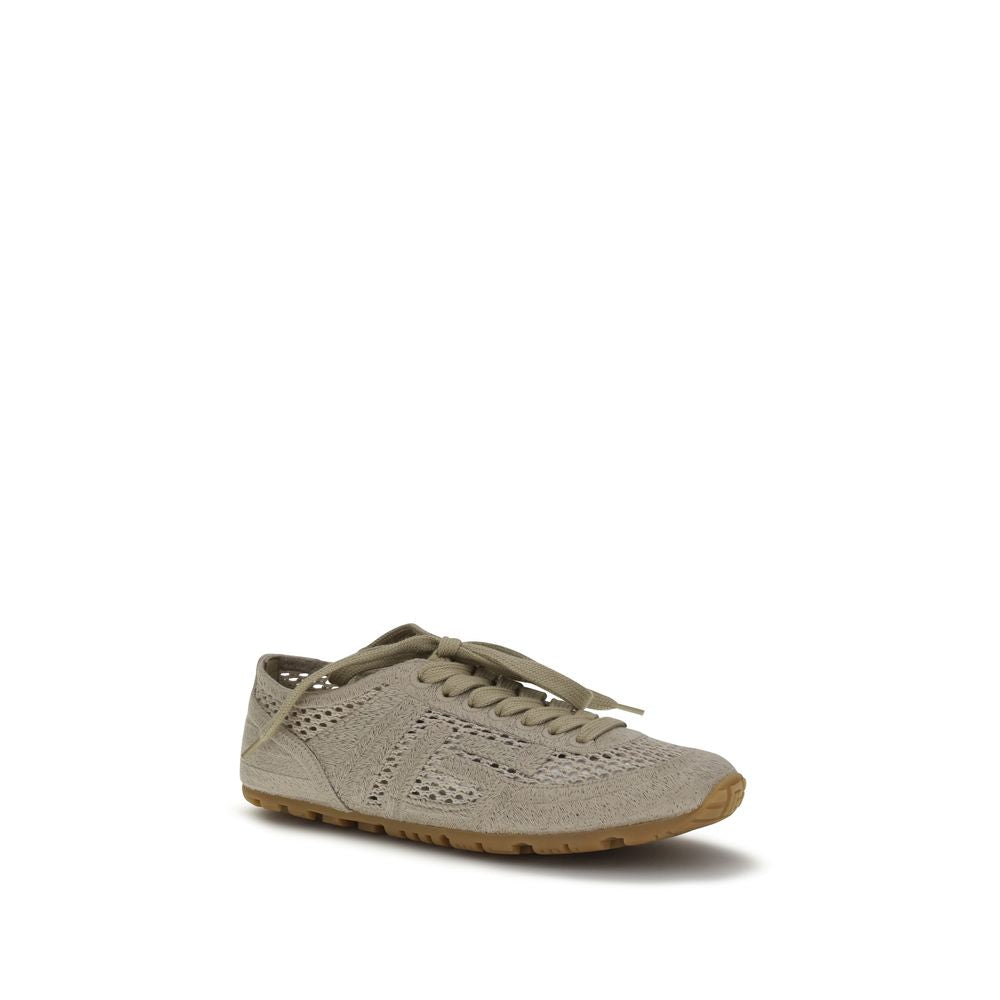Sneakers athlétiques beige en coton de la marque Balmain, vue rapprochée montrant le design et la texture du tissu.