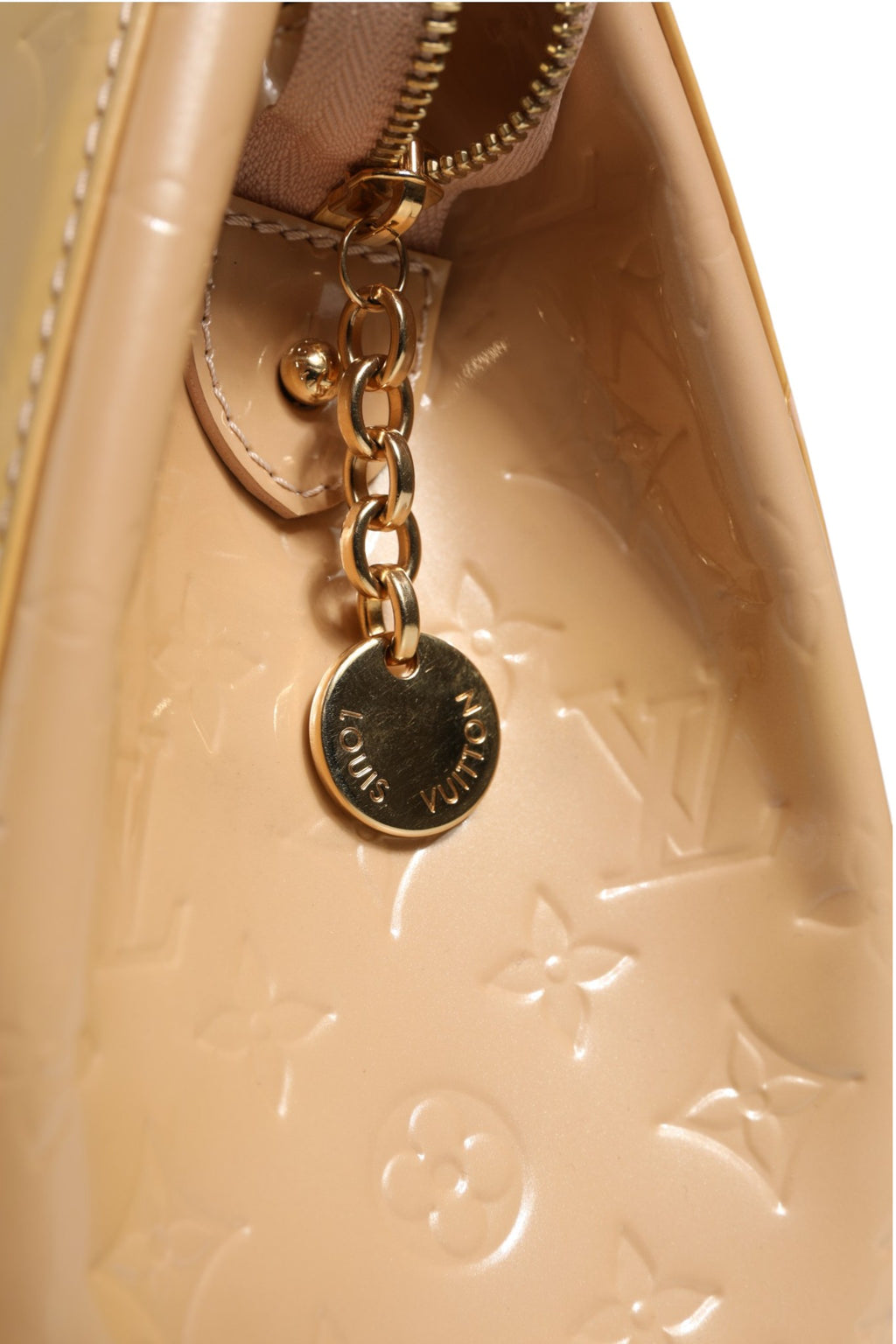 Sac Louis Vuitton Monogram Vernis Brea MM beige poudré, finition brillante et élégante, avec poignées en cuir et fermeture métallique.