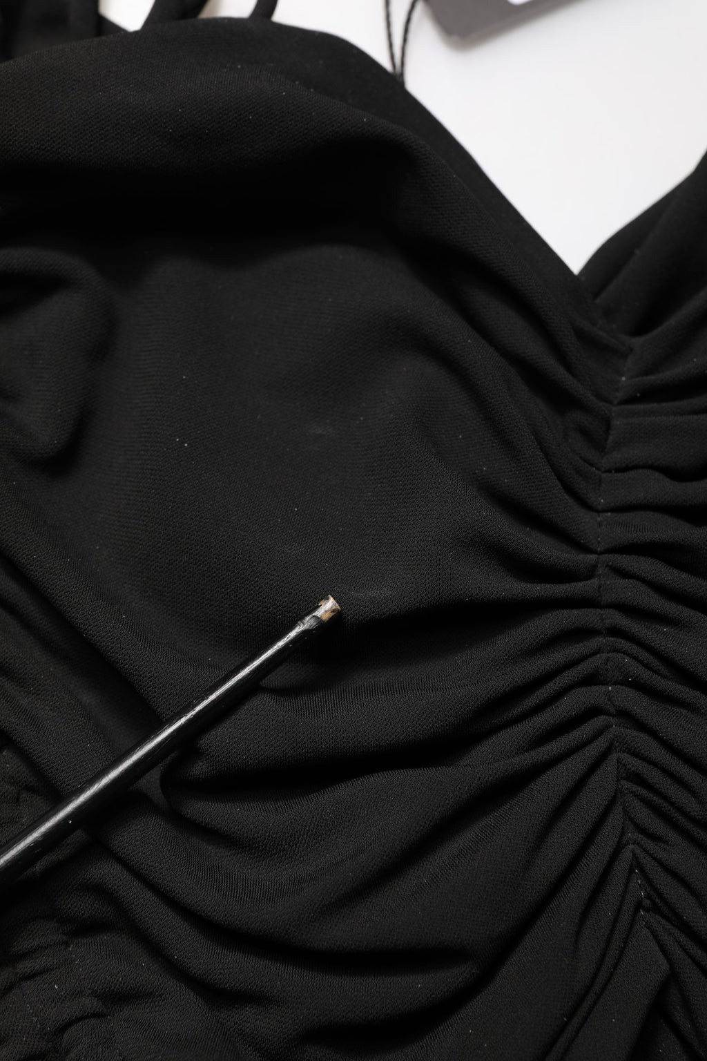Robe noire en jersey Dolce & Gabbana, longueur calf, avec découpes, drapée et détails ruchés.