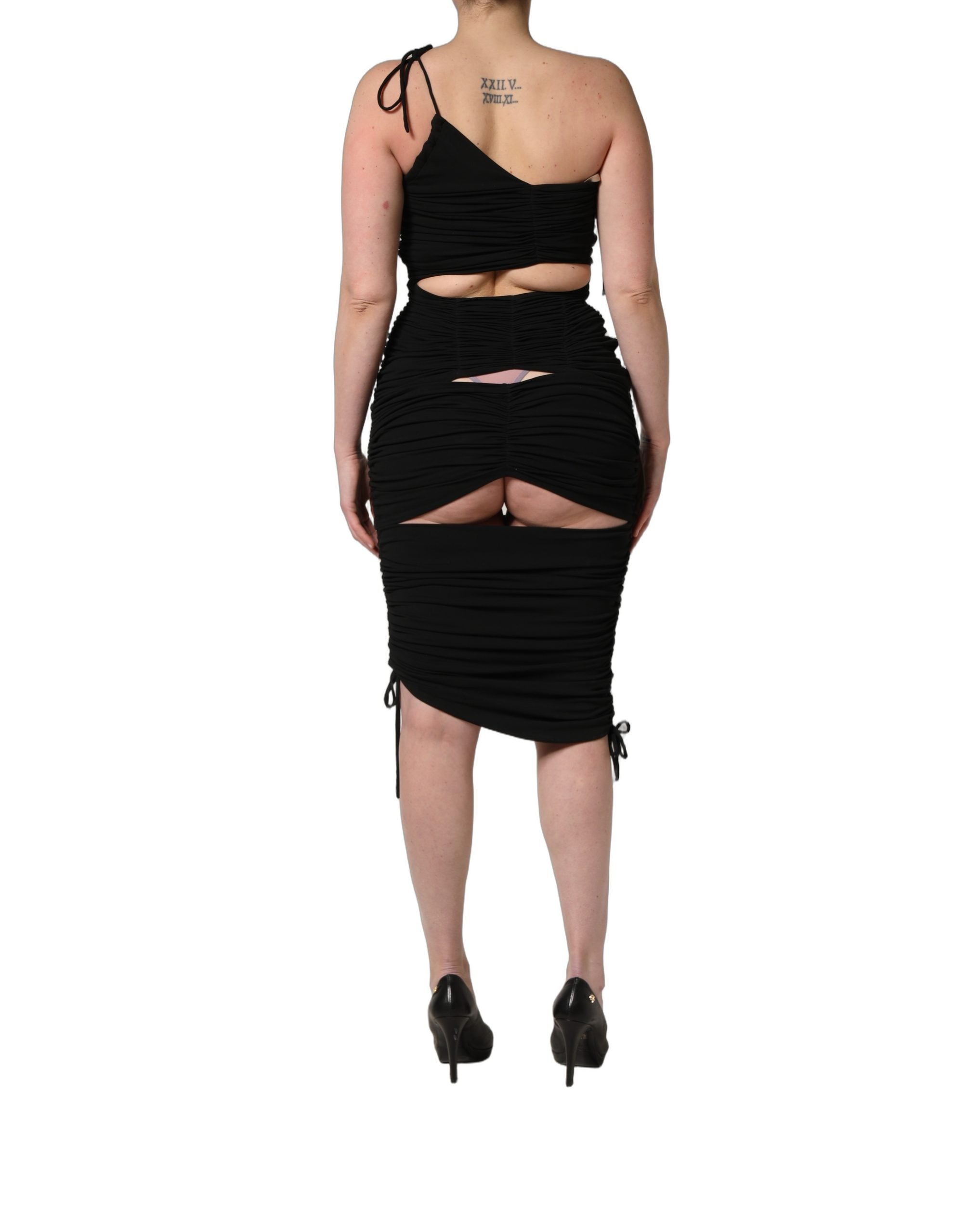 Robe noire en jersey Dolce & Gabbana, longueur calf, avec découpes et détails froncés, élégante et sophistiquée.