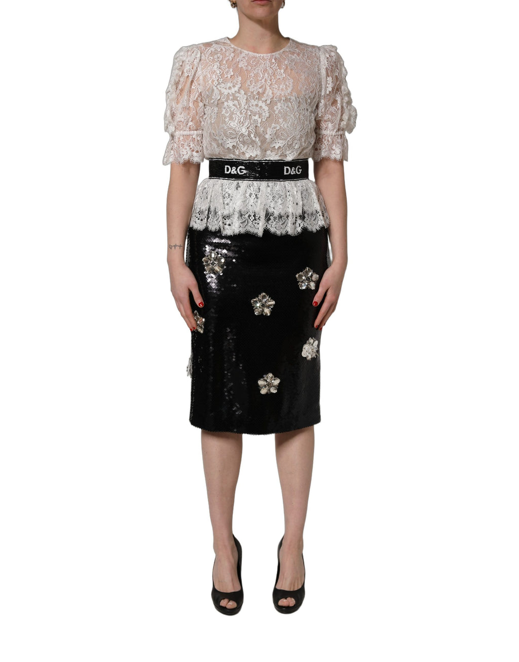 Robe Dolce & Gabbana blanche en dentelle avec embellissements, associée à une jupe noire élégante.