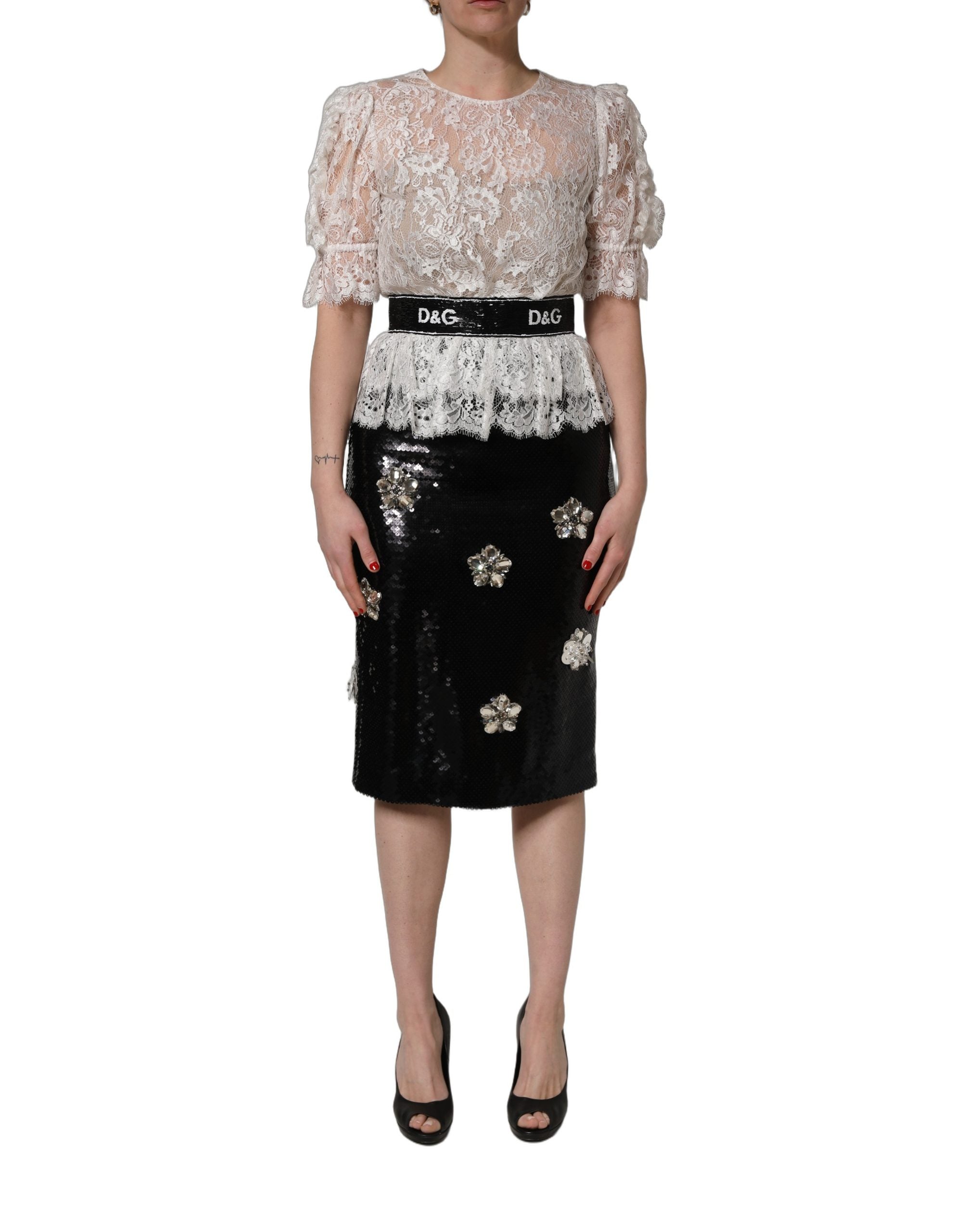 Robe Dolce & Gabbana blanche en dentelle avec embellissements, associée à une jupe noire élégante.