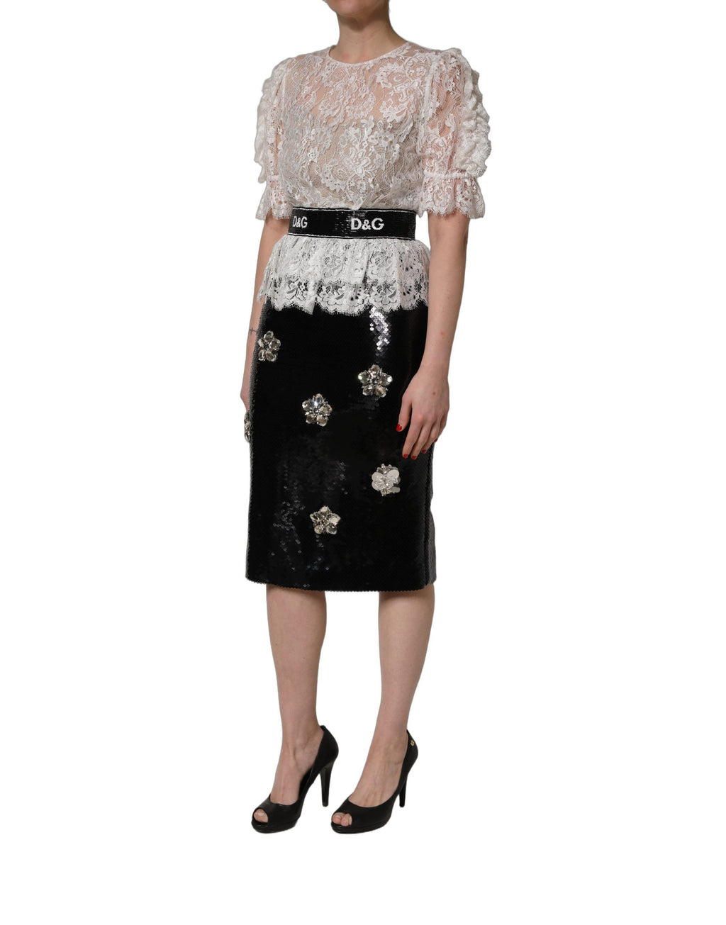 Robe Dolce & Gabbana blanche en dentelle avec détails brodés, associée à une jupe noire élégante.