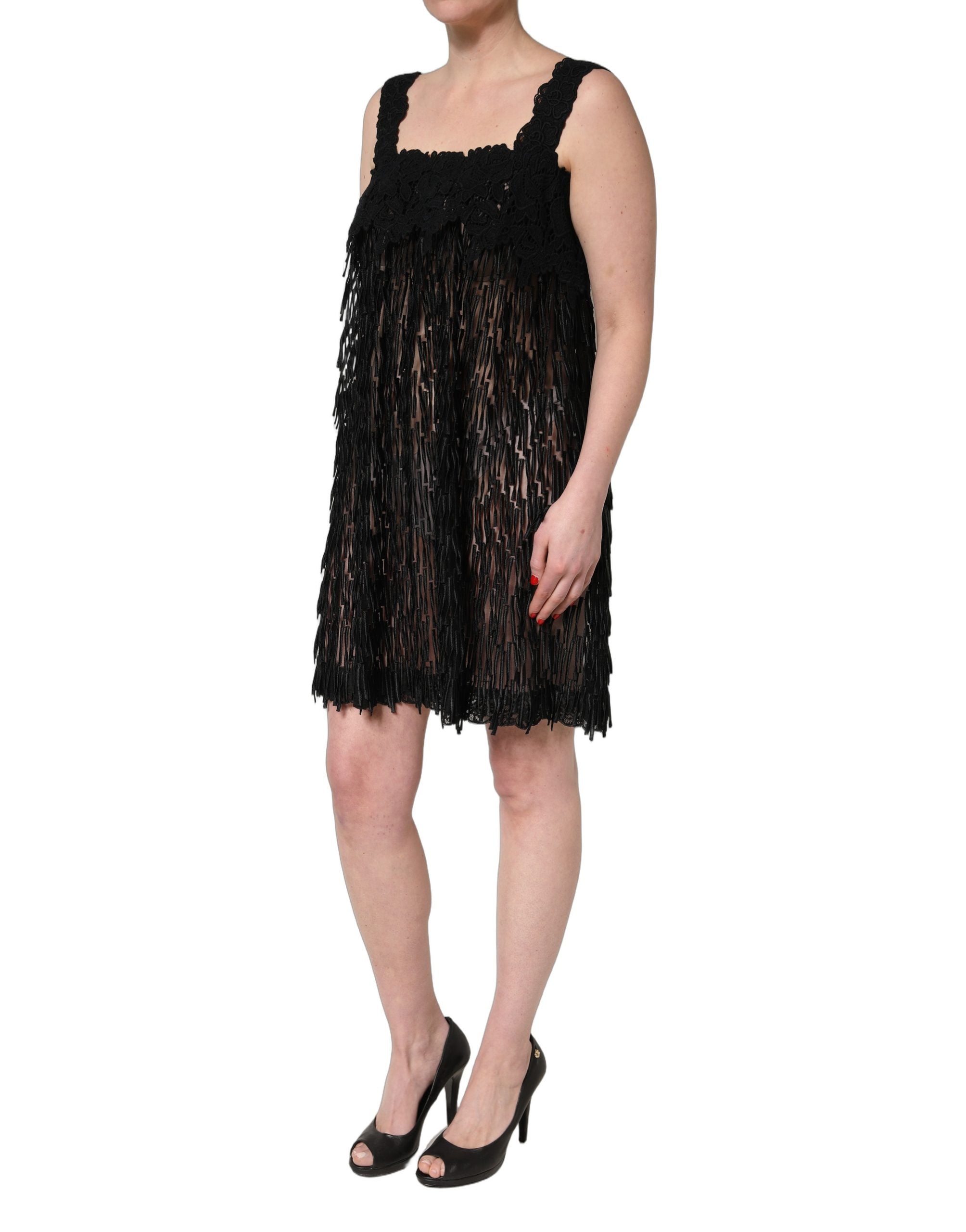Robe courte sans manches en viscose noire Dolce & Gabbana avec franges, élégante et moderne, portée sur un fond neutre.