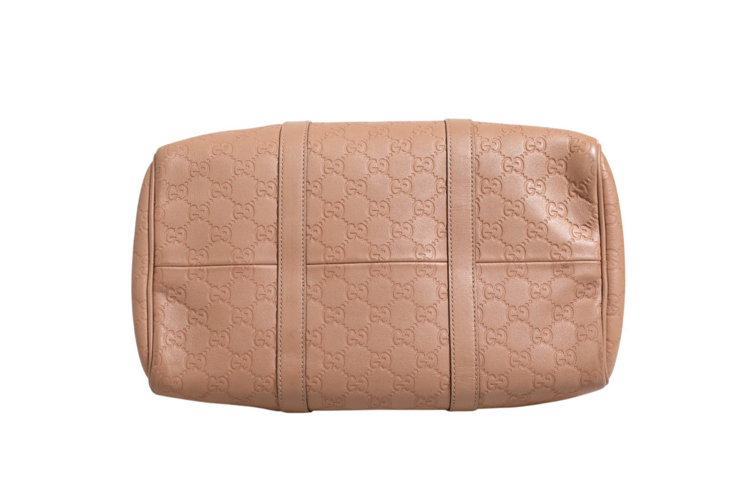 Sac à main Gucci Joy Boston en cuir marron avec détails en or, montre une grande poignée et une fermeture métallique.