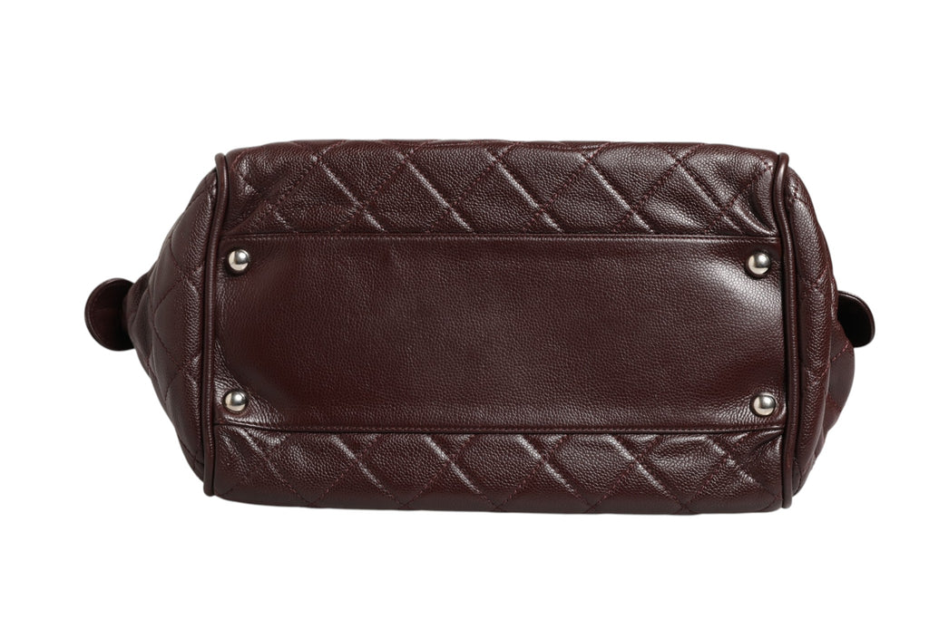 Sac Chanel Timeless Bowler, en cuir noir avec détails en métal doré et poignées courbes, élégant et classique.