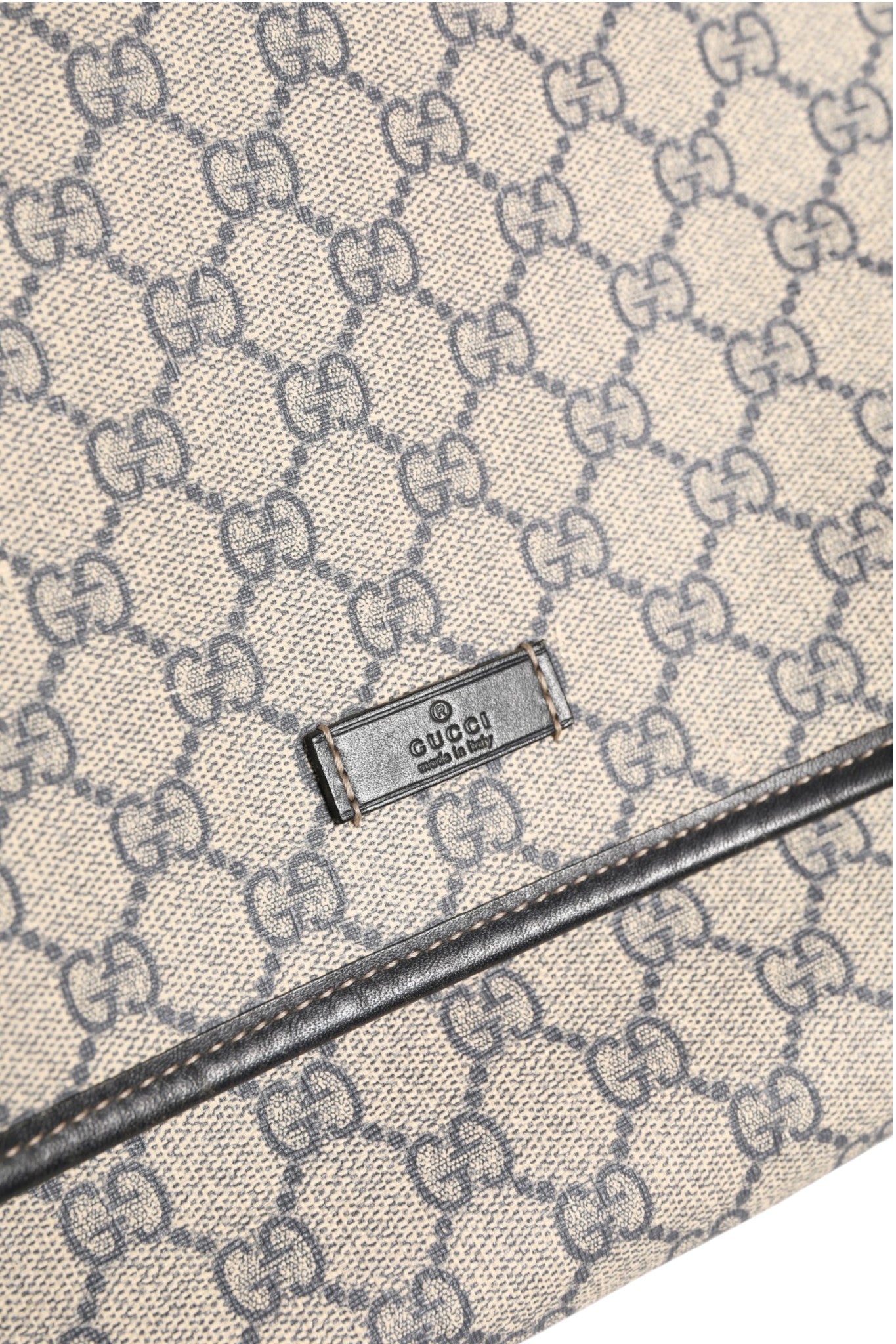 Sac messenger Gucci GG Supreme en toile avec détails en cuir, logo Gucci visible, style élégant et sophistiqué.