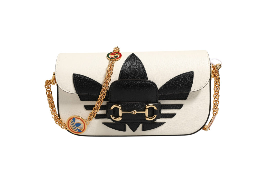 Sac à bandoulière Gucci x Adidas Horsebit 1955 en noir et blanc, avec logo et détails en métal, design élégant et moderne.
