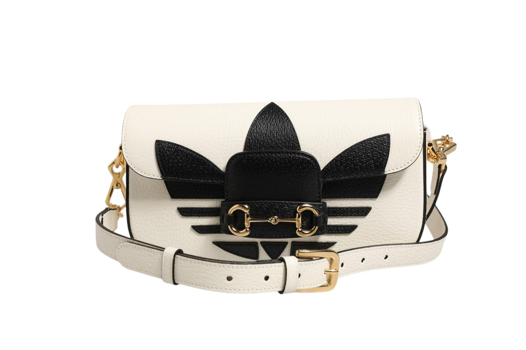 Sac à shoulder Gucci x Adidas Horsebit 1955 en noir et blanc, avec détails emblématiques et logo visible.
