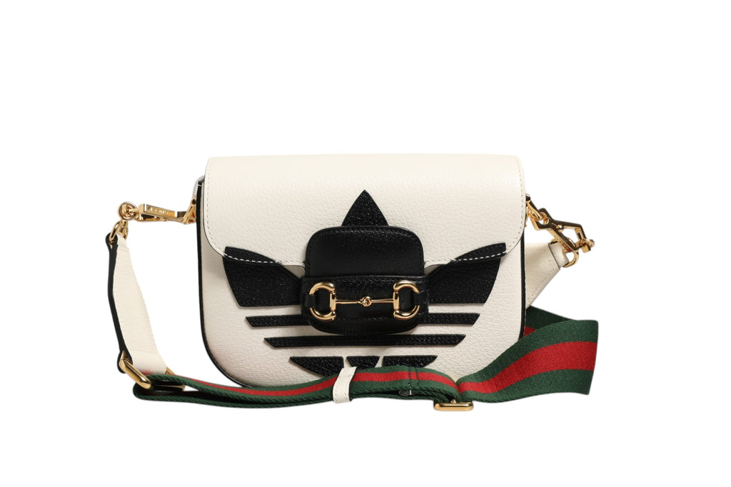 Sac à épaules Gucci x Adidas 1955 Horsebit avec logo, design élégant, en cuir noir et détails en or, visible en gros plan.