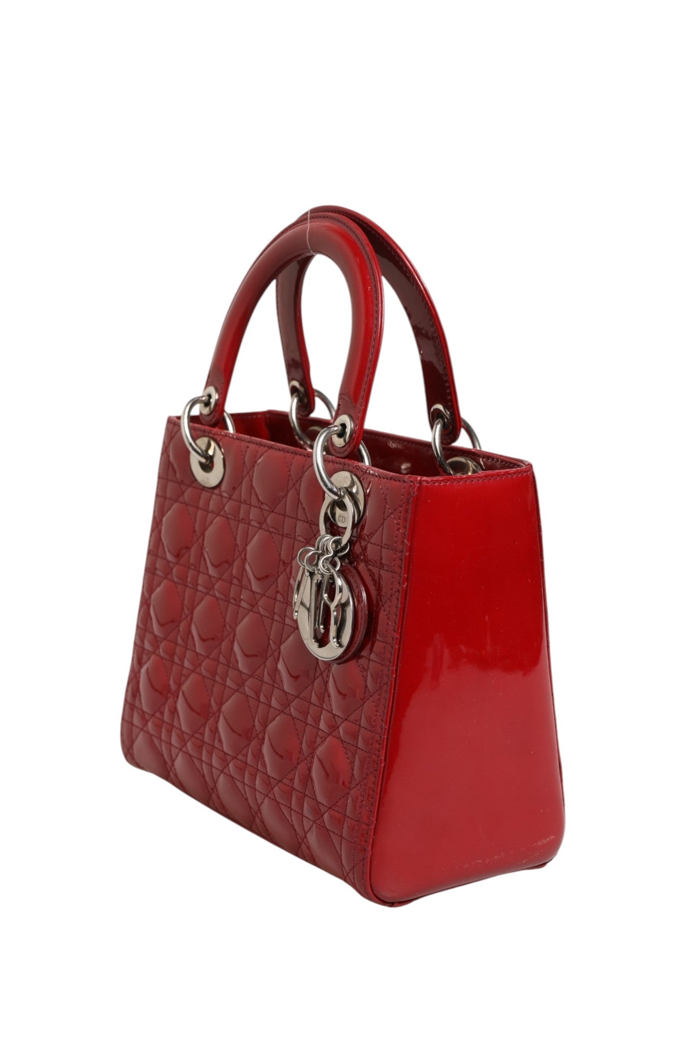 Petit sac Lady Dior en cuir verni rouge cerise avec quilting Cannage, signature de la marque Christian Dior.