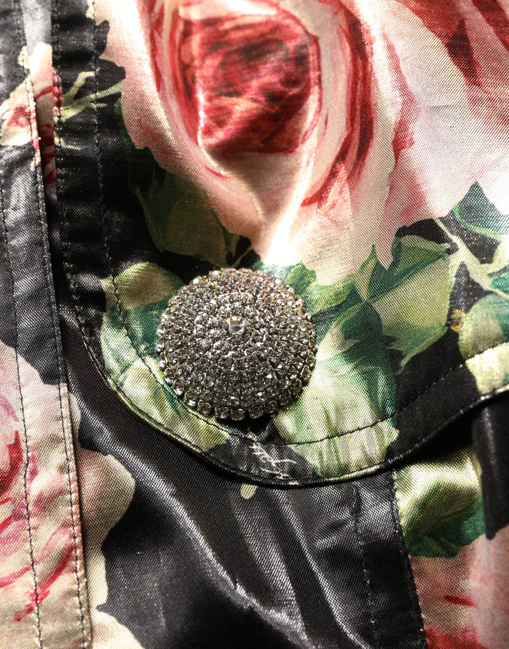 Manteau trench noir en polyester à fleurs avec ceinture, signé Dolce & Gabbana, visible en détail dans l'image.