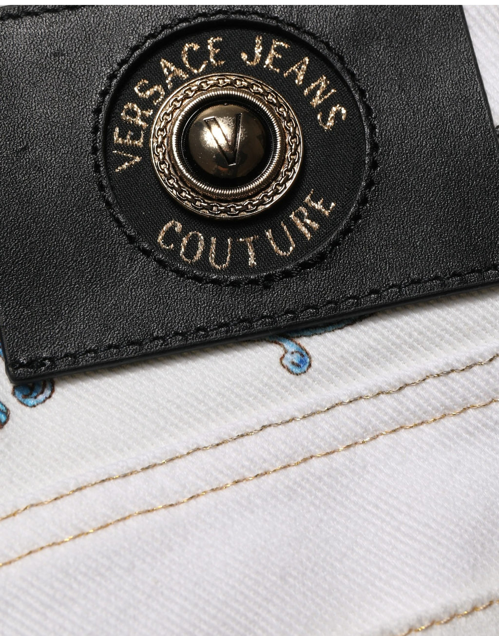 Jeans skinny en denim blanc à imprimé floral de Versace Jeans Couture, visibles avec détails de couture et coupe ajustée.