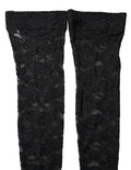 Chaussettes hautes en dentelle florale noire de Dolce & Gabbana, élégantes et sophistiquées, visibles sur la jambe.