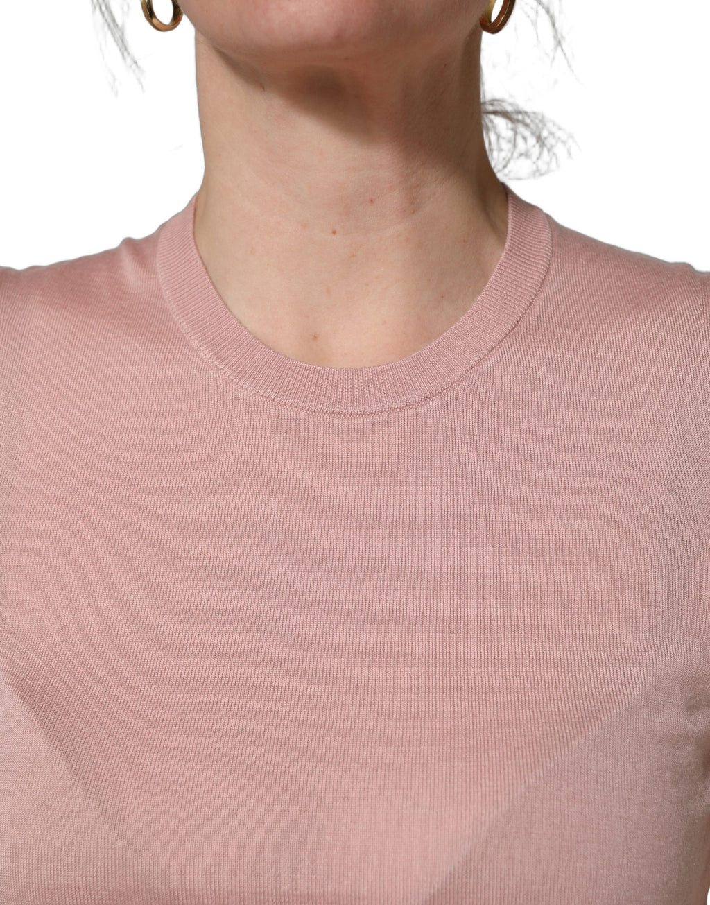 Débardeur en cachemire rose sans manches de Dolce & Gabbana, tricoté avec détail élégant, porté sur un fond neutre.