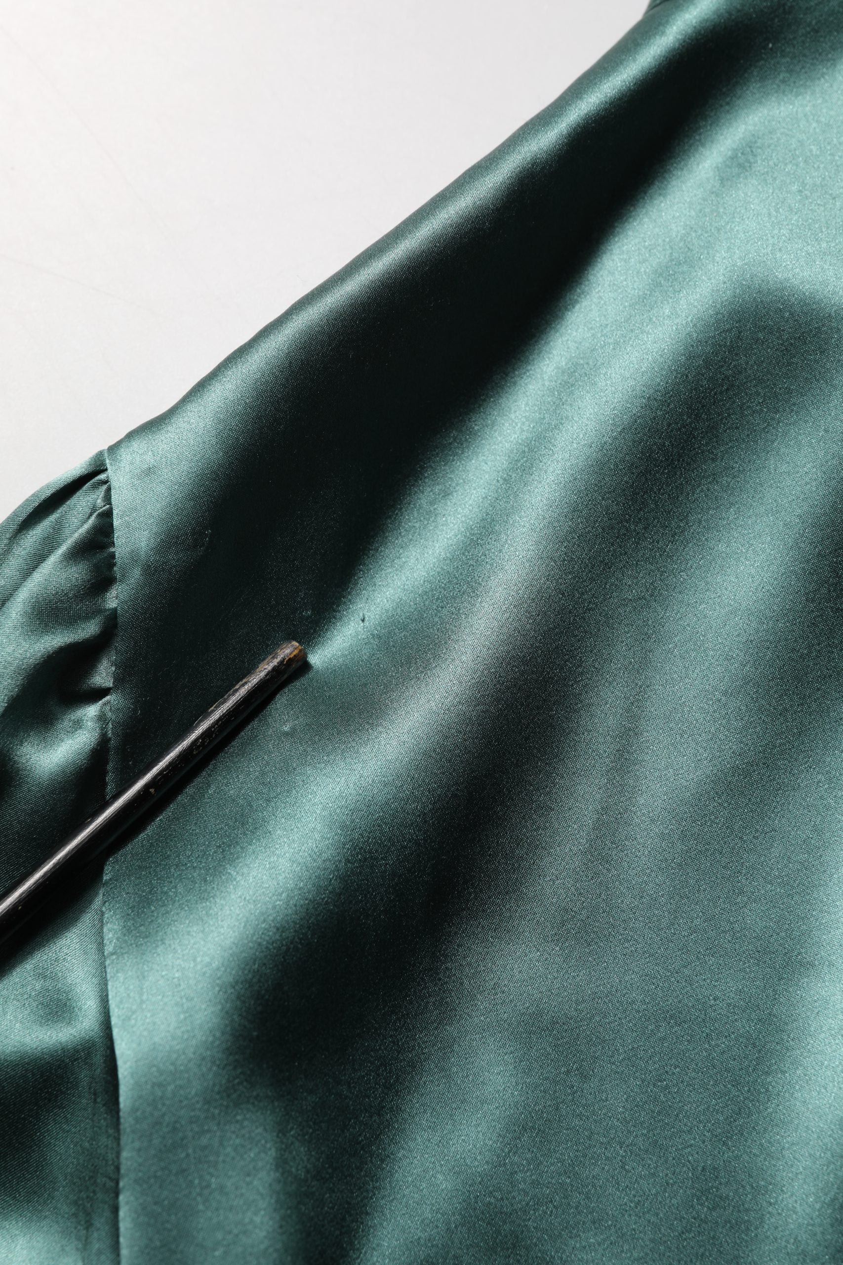 Chemise en soie satin vert foncé de Dolce & Gabbana avec nœud au cou, élégant top à manches longues.