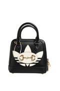 Mini sac Gucci x Adidas Horsebit 1955 avec logo, en cuir noir et détails dorés, porté avec bandoulière réglable.