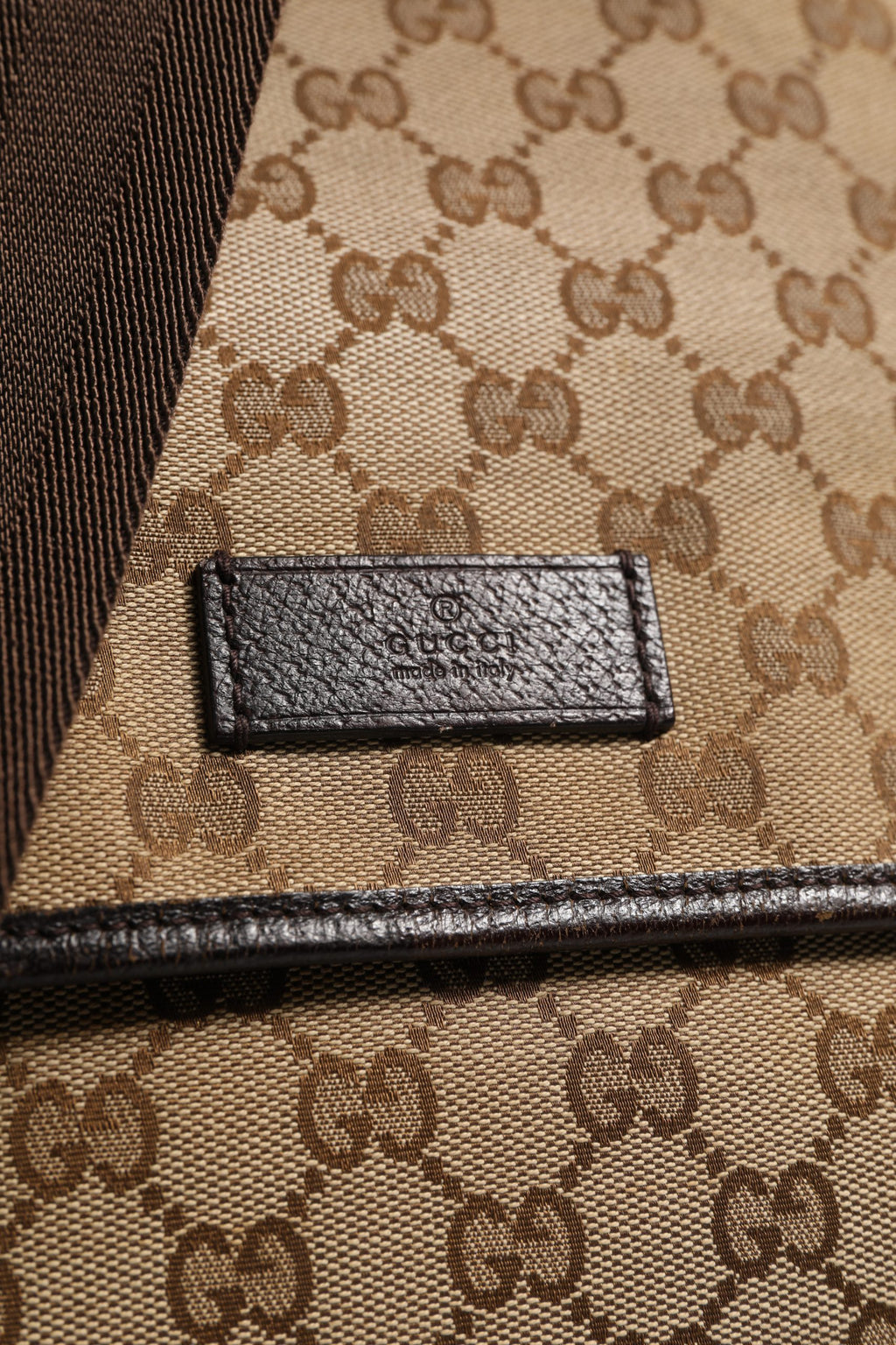 Sac à messenger Gucci GG Canvas avec rabat, en toile monogramme, porté sur l'épaule, style élégant et chic.