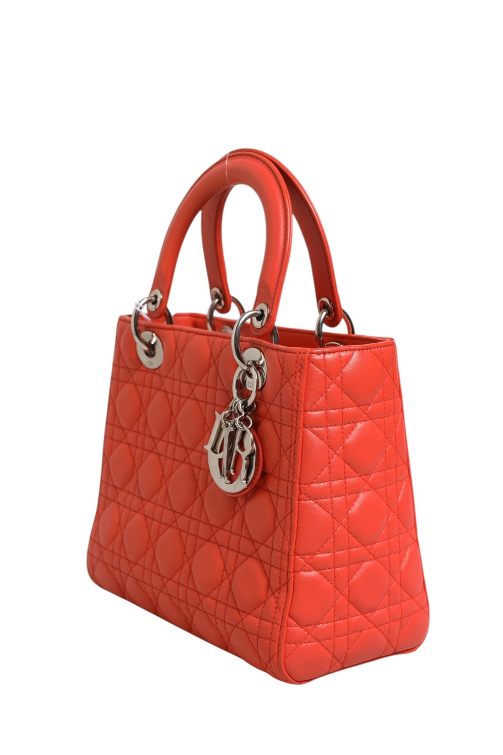 Sac à main Lady Dior en cuir d'agneau orange avec motif Cannage de Christian Dior, élégance classique et moderne.