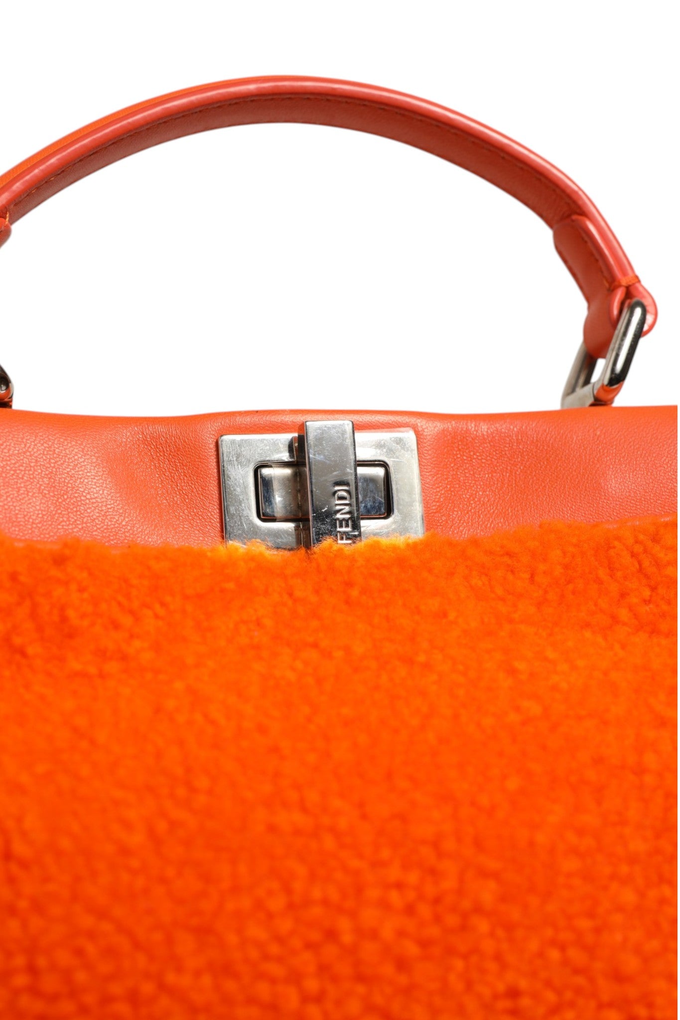 Sac Fendi mini Peekaboo en cuir orange et shearling, poignée en haut avec détails élégants et intérieur spacieux.
