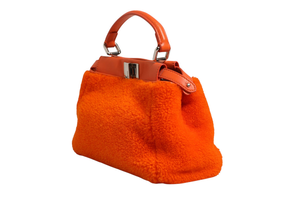 Sac à main Fendi Peekaboo mini en cuir orange et shearling, avec poignée supérieure et design élégant.