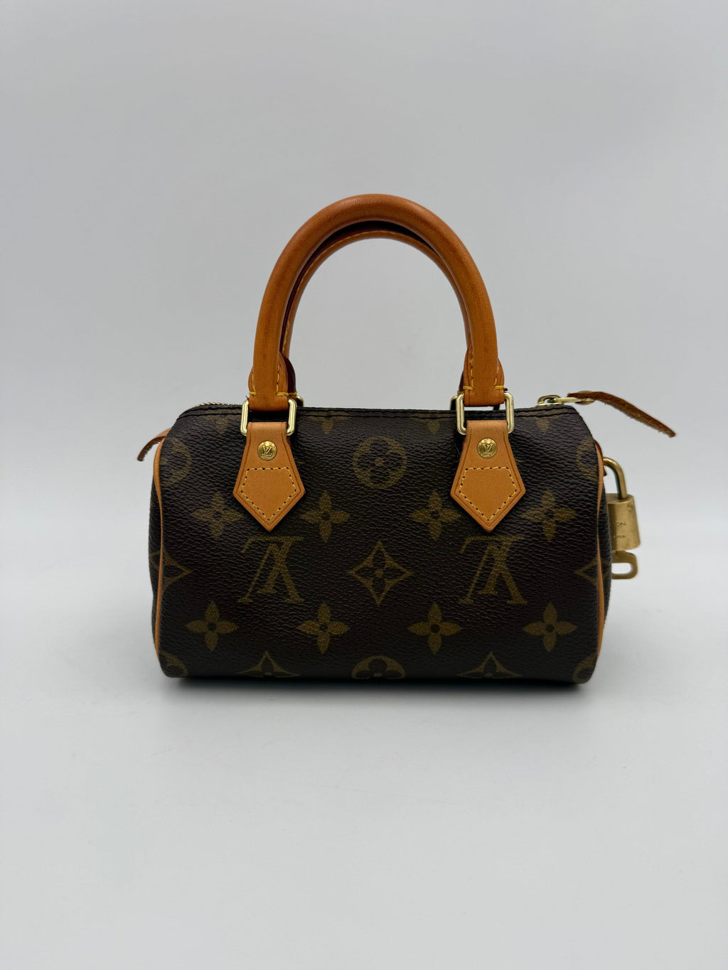 Sac à main Louis Vuitton Nano Speedy Monogram en toile avec poignée en cuir et logo LV visible.