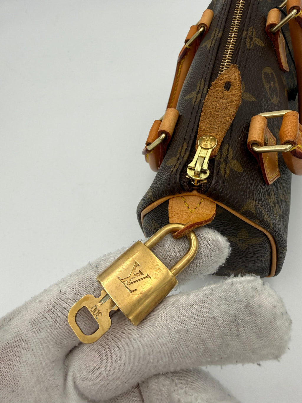 Sac à main Nano Speedy Louis Vuitton Monogram, petit sac en cuir avec motifs emblématiques, poignée en cuir et fermeture métallique.
