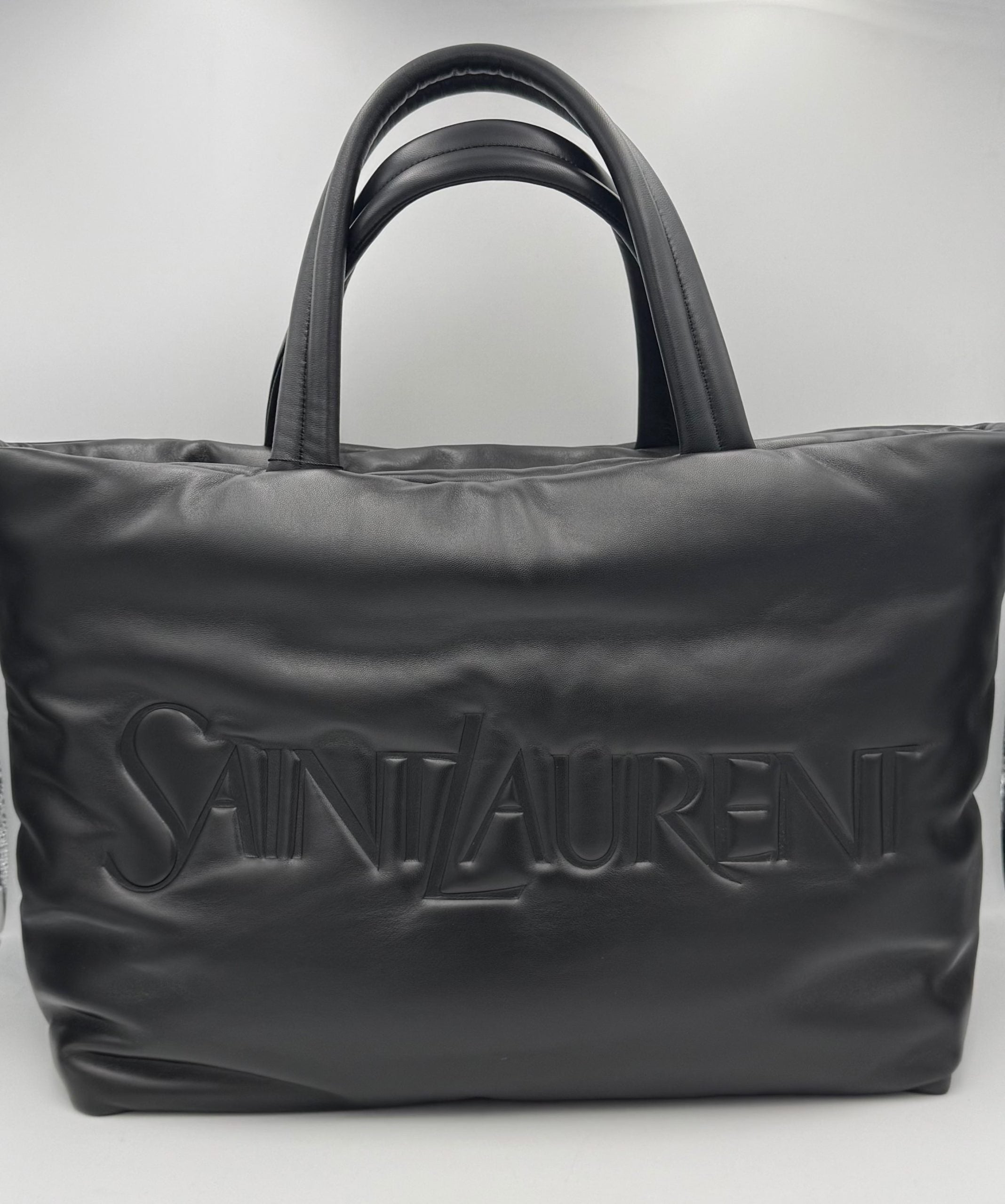 Grand sac shopping Saint Laurent SAINT LAURENT en cuir d'agneau, visible avec poignées et logo emblématique sur le devant.