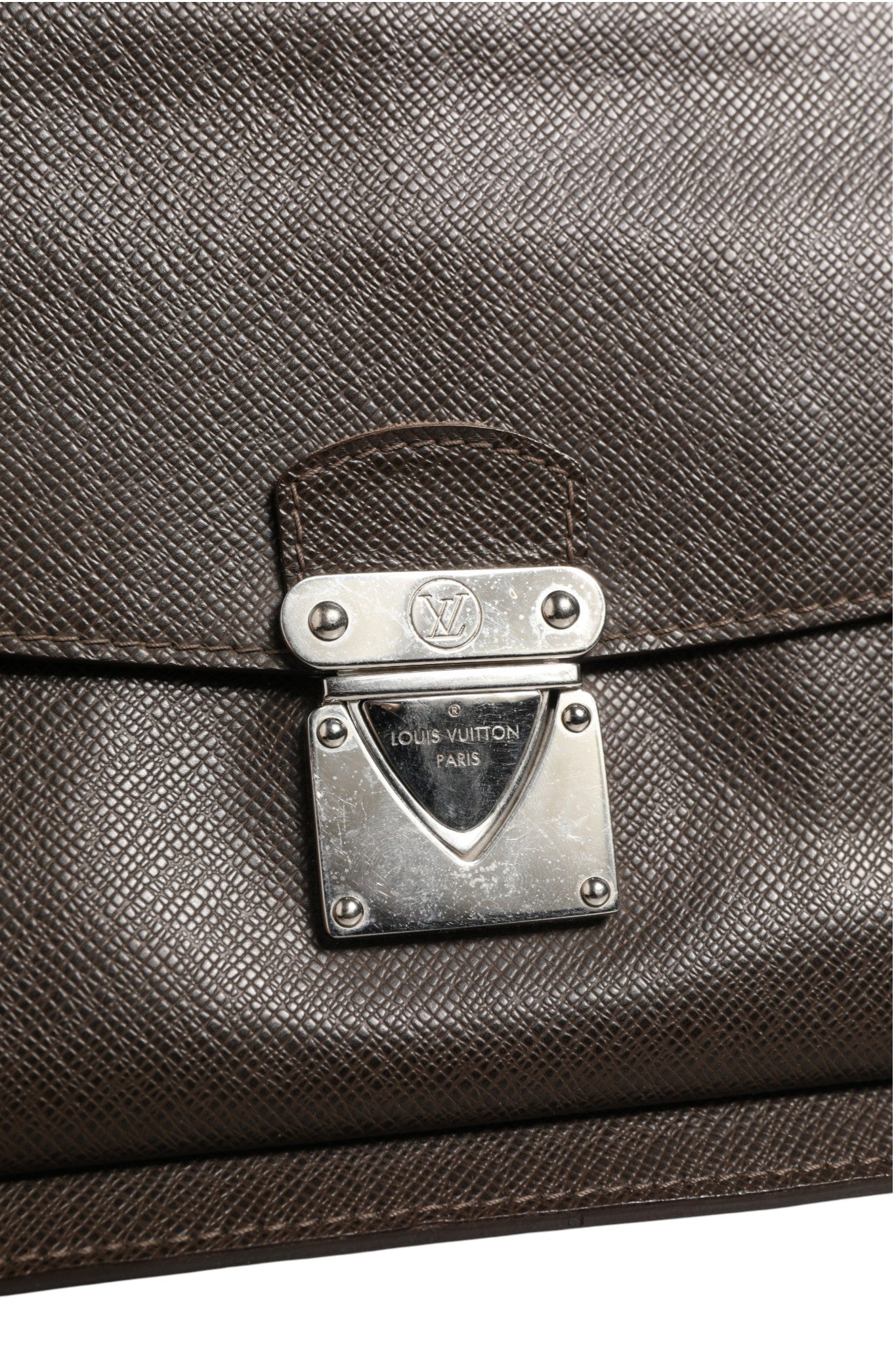 Pochette Louis Vuitton Belaia en cuir Taiga beige avec fermeture à glissière et logo embossé en relief.