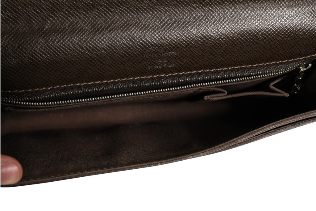 Pochette Louis Vuitton Belaia en cuir Taiga, élégante et sophistiquée, avec fermeture lumineuse et détails raffinés visible en image.