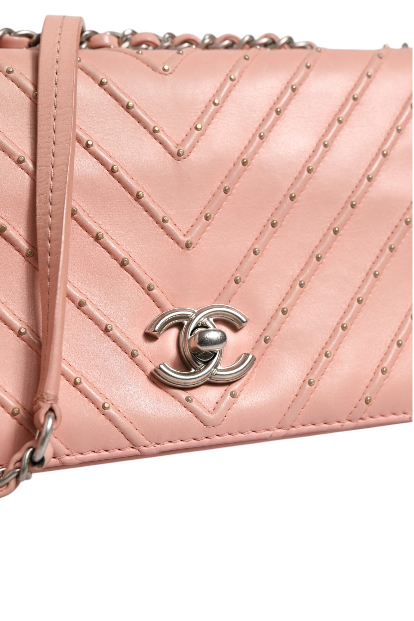 Sac Chanel Small Classic Double Flap en cuir rose clair à motif Chevron, avec chaîne en métal et logo emblématique.