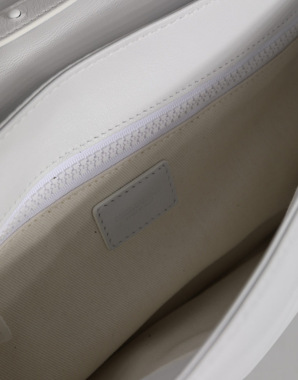 Sac à bandoulière Dolce & Gabbana blanc avec plaque logo, design élégant pour femmes, visible avec poche et bandoulière réglable.