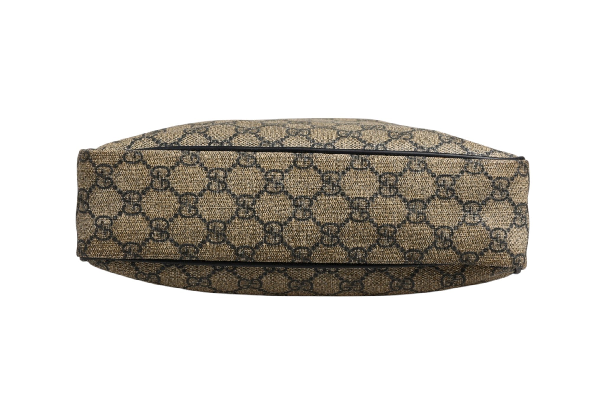 Sac messenger Gucci Supreme en toile avec détails en cuir, porté en bandoulière, visible avec logo Gucci sur le devant.
