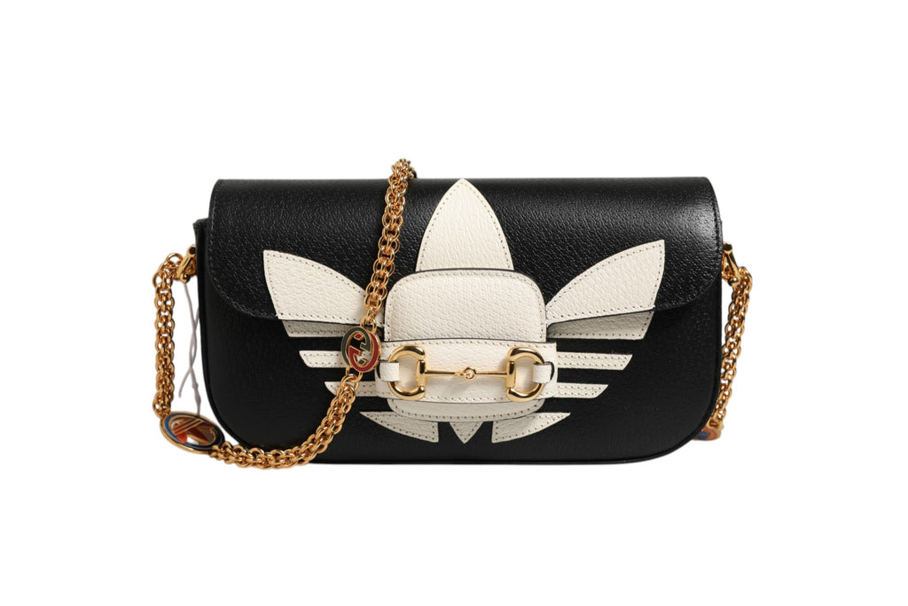 Sac à main Gucci Horsebit 1955 avec bandoulière, en cuir noir, orné de détails dorés et logo Gucci visible sur la surface.