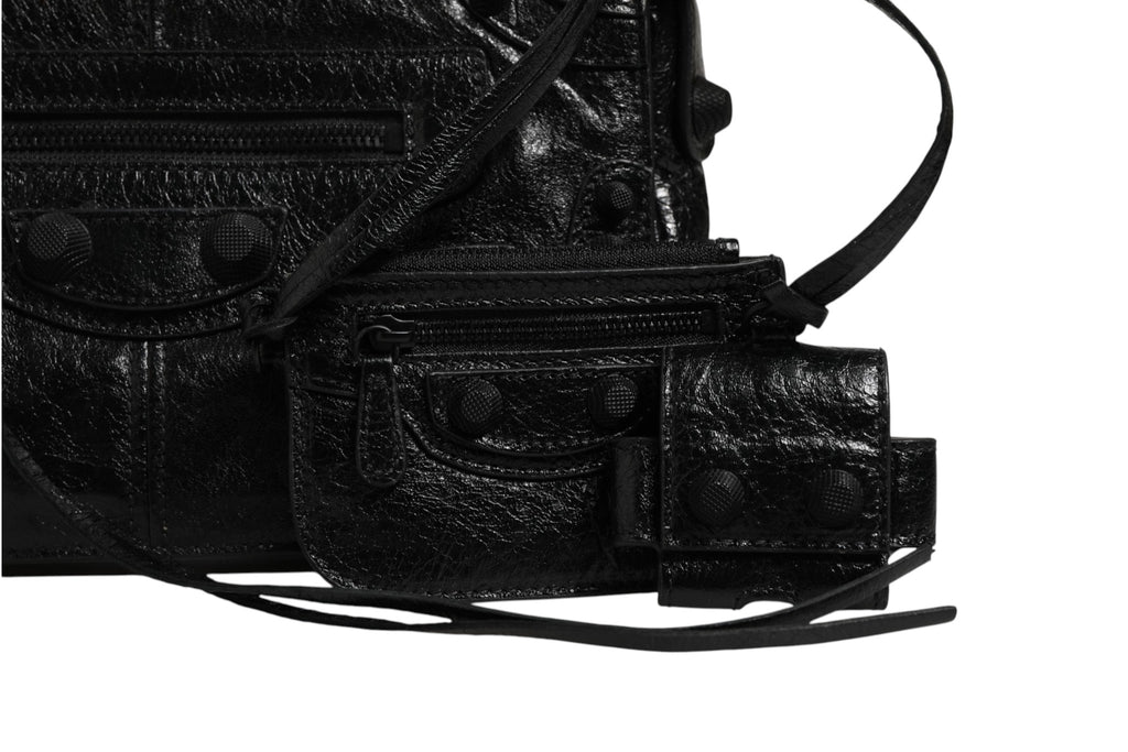 Petite sac à rabat Balenciaga Le Cagole XS en cuir avec chaîne dorée, détails de couture et logo visible, vue de face.