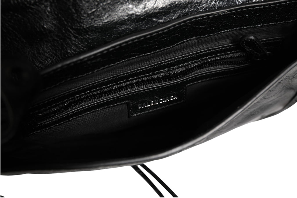 Sac à main Balenciaga Le Cagole XS Flap Bag en cuir, avec chaîne en métal et fermeture à rabat, vue en gros plan.