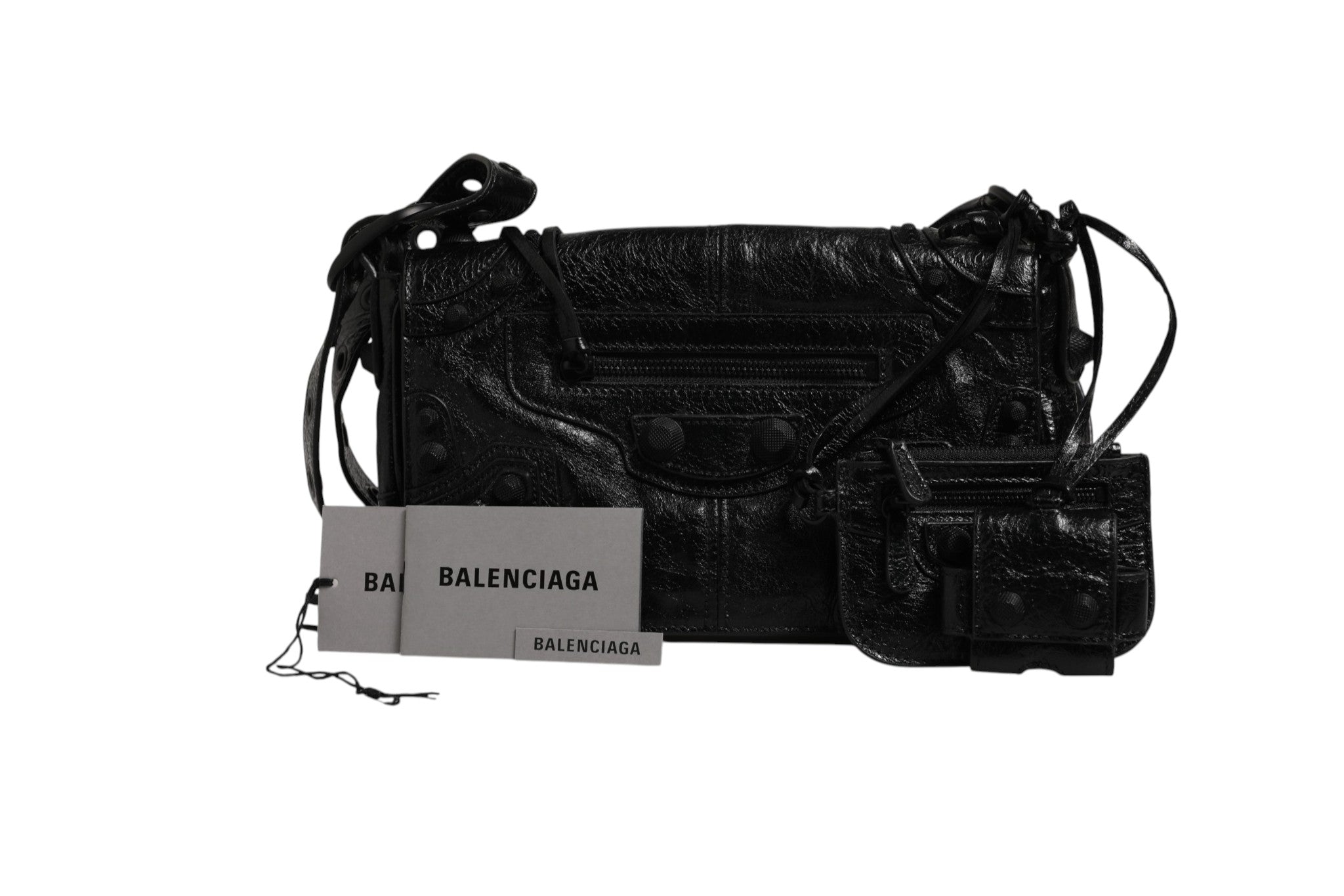 Petite sac à rabat Balenciaga Le Cagole XS avec bandoulière en cuir noir et détails métalliques.