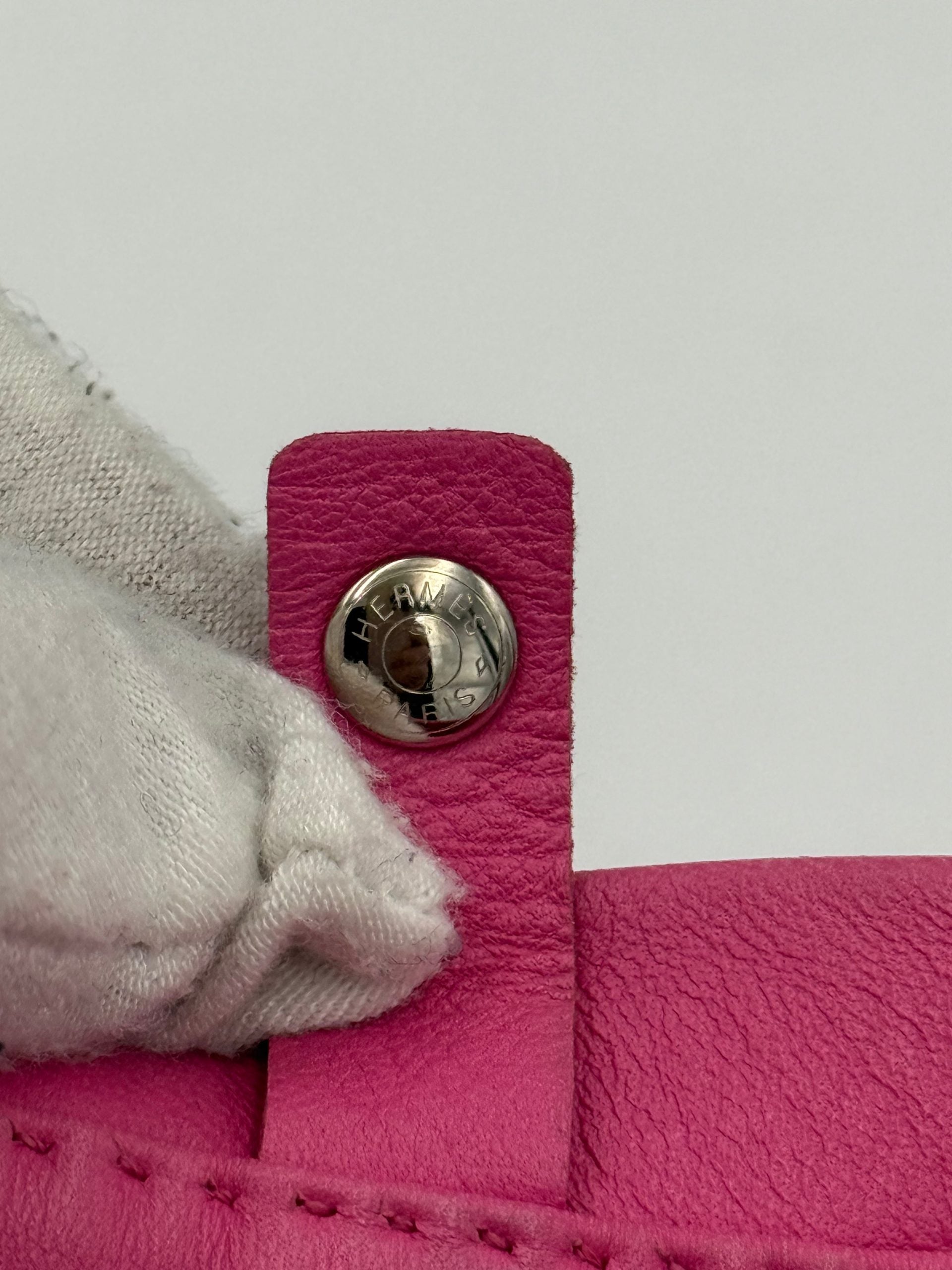 Sac à main Hermès Clou de Selle, cuir élégant avec détails en métal, en position sur fond blanc.